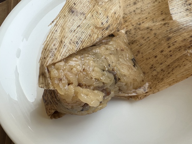 竹の皮包みを開いたおこわの写真