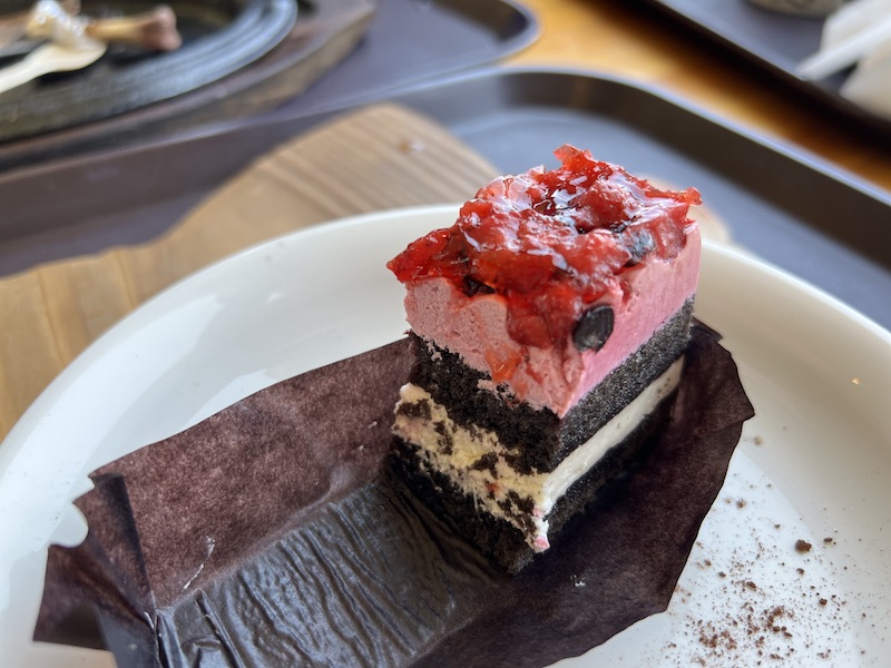 ベリーベリーケーキの断面図。上からベリーのソース、ムース、チョコレートスポンジ、クリーム、チョコレートスポンジ